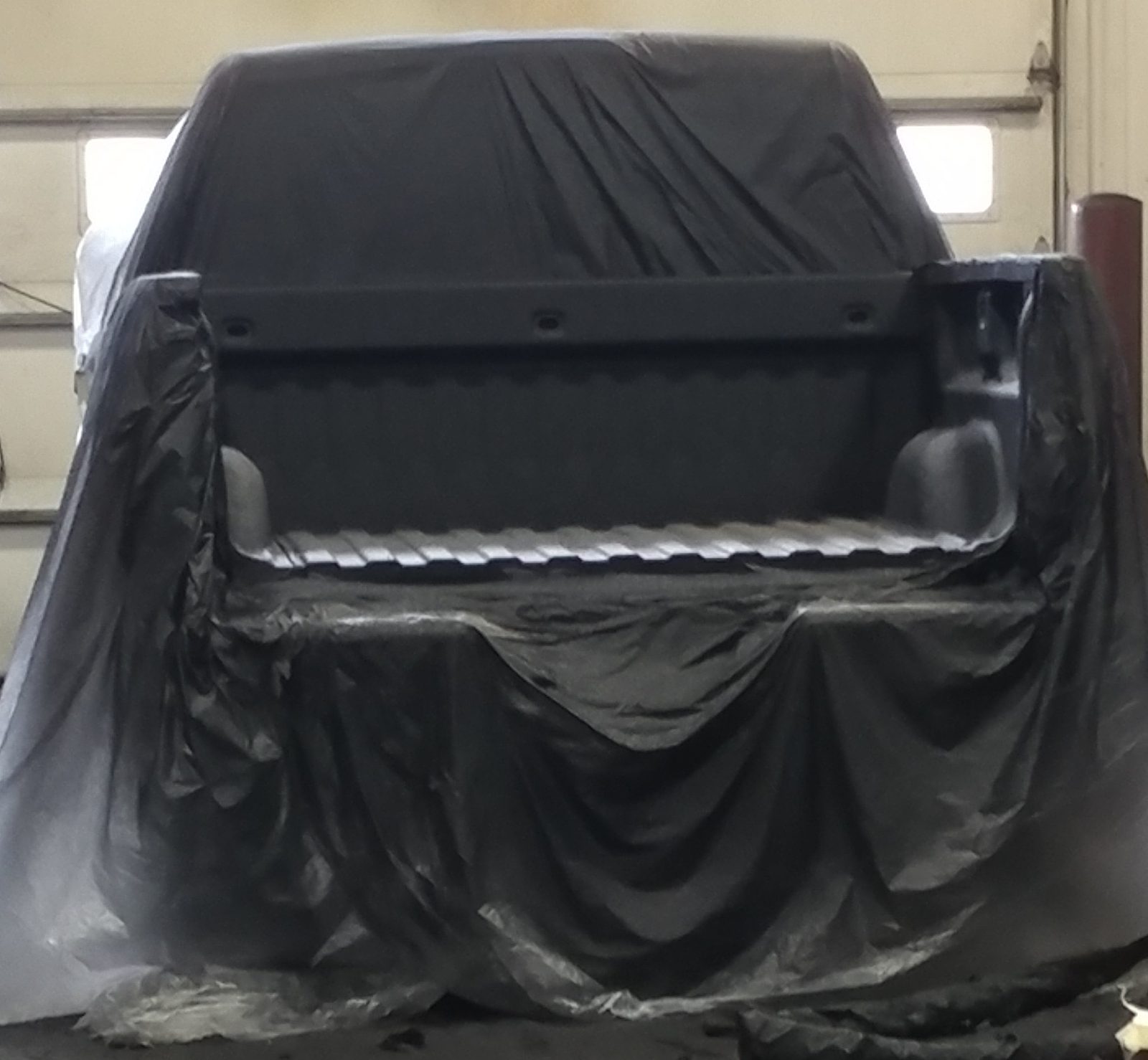 Barrier layer being sprayed over primed steel
